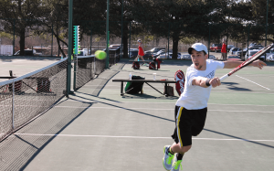 Junior Woody Rini sends a shot over the net during a match earlier this season. The team is set to host Brescia University on Fri., April 18.